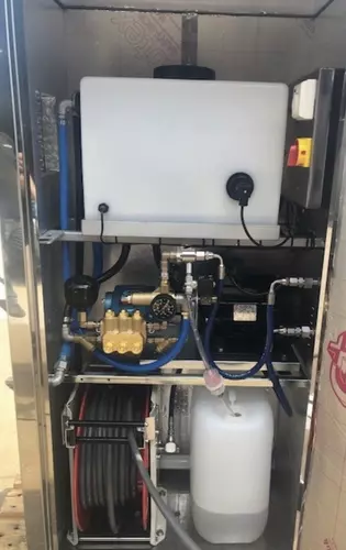 Internal view of the bespoke wheel wash system showing the CAT pump, inlet water tank, chemical setup, and integrated hose reel. Designed for reliability, ease of maintenance, and a clean, organised layout within the stainless steel cabinet.